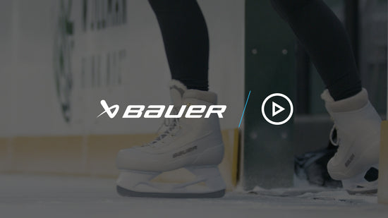 close up on a pair of white ice skates gliding out onto the ice